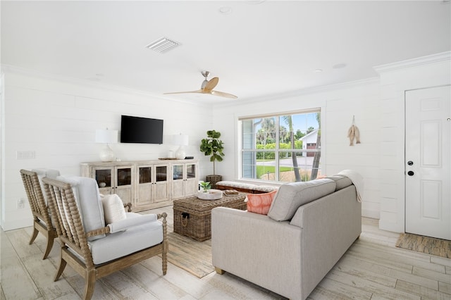 living room featuring ceiling fan, light hardwood / wood-style flooring, and ornamental molding