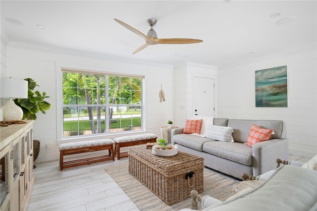 living room with light hardwood / wood-style floors, ceiling fan, and ornamental molding