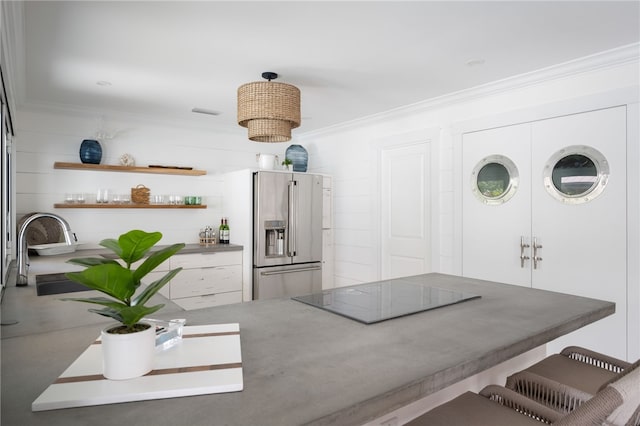 interior space featuring sink, black electric cooktop, ornamental molding, high end fridge, and concrete flooring