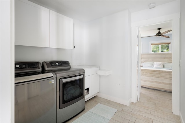 washroom featuring cabinets, light hardwood / wood-style floors, washer and clothes dryer, and ceiling fan