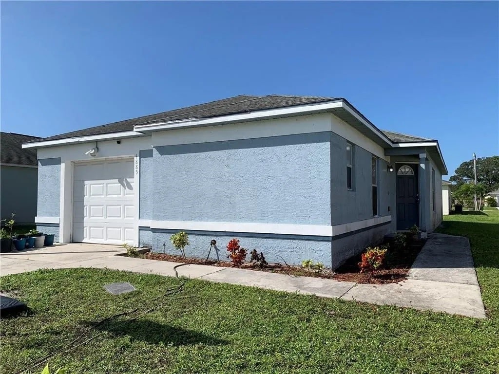 view of property exterior featuring a garage and a yard