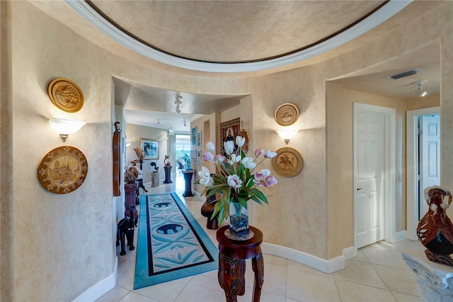 hallway featuring light tile patterned flooring and ornamental molding