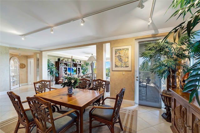 dining space featuring track lighting, light tile patterned floors, and ornamental molding