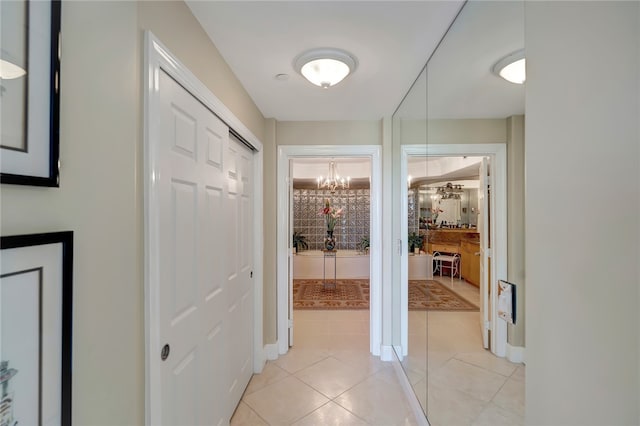 corridor featuring a notable chandelier and light tile patterned floors