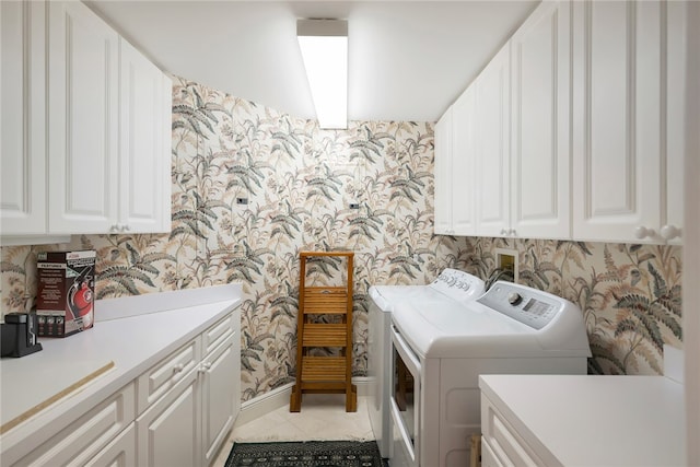 laundry room featuring cabinets, light tile patterned floors, and separate washer and dryer