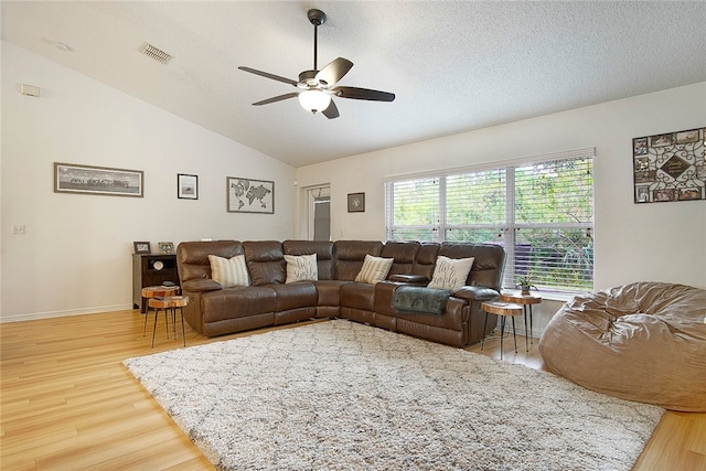 living room with wood-type flooring, a textured ceiling, ceiling fan, and lofted ceiling