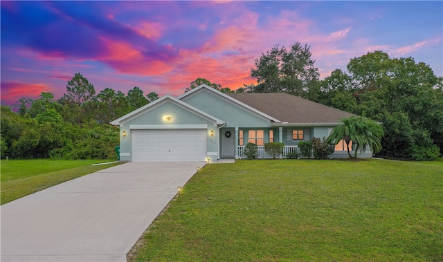 ranch-style house featuring a yard, a porch, and a garage