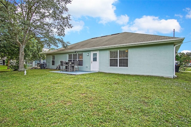 rear view of property with a yard and a patio