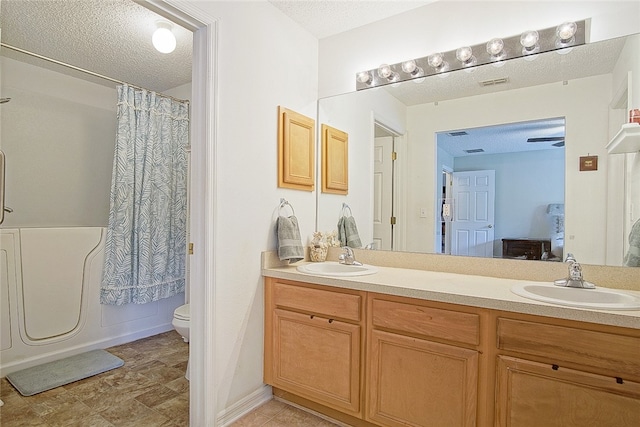 full bathroom featuring vanity, toilet, shower / bathtub combination with curtain, and a textured ceiling