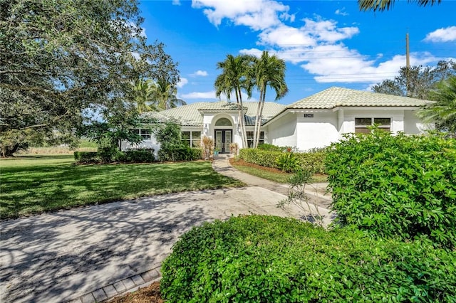 mediterranean / spanish house featuring a front lawn