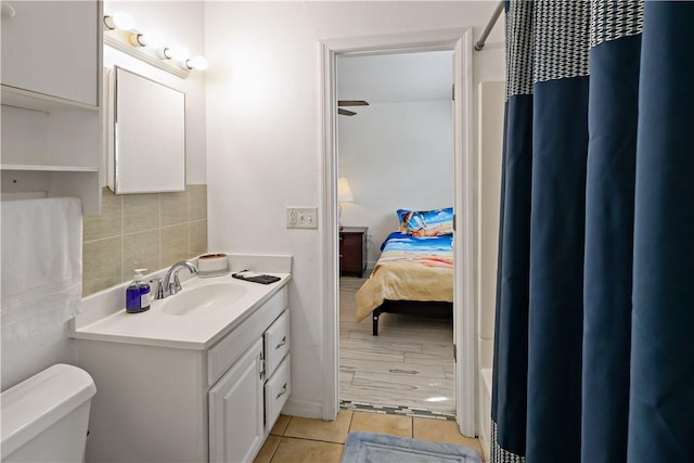 1311 3rd Ct, Vero Beach, FL 32960 - ensuite bathroom with tile patterned flooring, vanity, decorative backsplash, and toilet