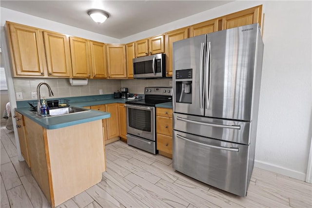 1311 3rd Ct, Vero Beach, FL 32960 - kitchen featuring appliances with stainless steel finishes, a sink, dark countertops, a peninsula, and tasteful backsplash