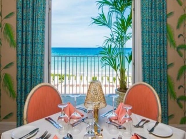 balcony with a water view and a view of the beach