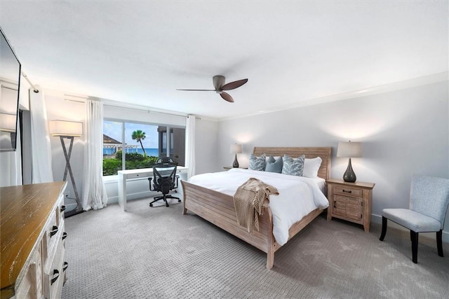 bedroom featuring light carpet, ornamental molding, and a ceiling fan