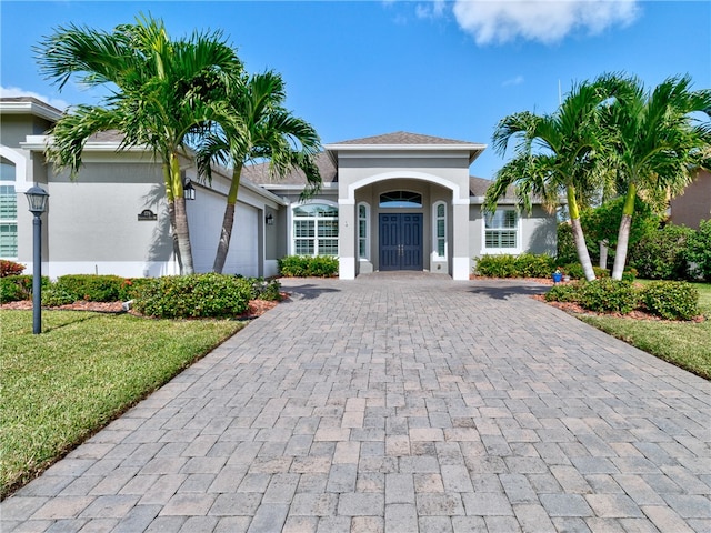 view of front of property with a garage and a front lawn