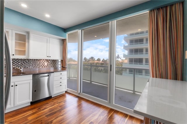 3554 Ocean Dr Unit 403S, Vero Beach, FL 32963 - kitchen with dishwasher, decorative backsplash, dark wood finished floors, and white cabinets