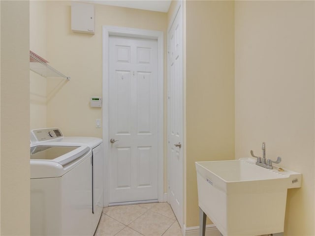 laundry area featuring light tile patterned flooring, sink, and independent washer and dryer