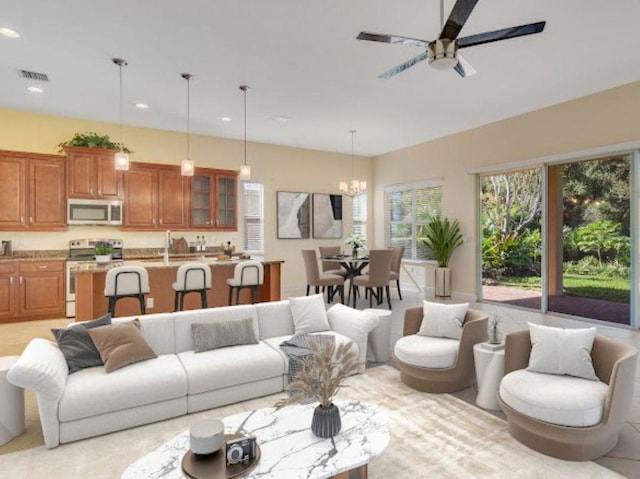 living room with ceiling fan with notable chandelier