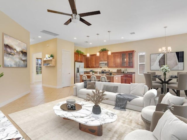 living room with light tile patterned flooring, ceiling fan with notable chandelier, and sink