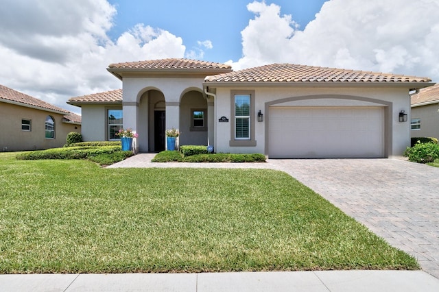 mediterranean / spanish home with a garage and a front yard