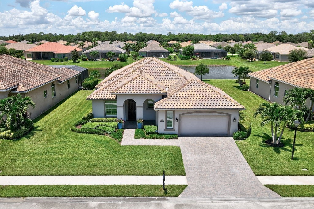 mediterranean / spanish-style house featuring a garage and a front yard