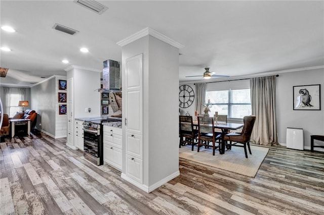 kitchen featuring ceiling fan, exhaust hood, light hardwood / wood-style flooring, white cabinets, and stainless steel electric range