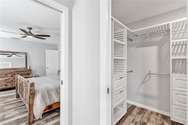 spacious closet featuring hardwood / wood-style flooring and ceiling fan