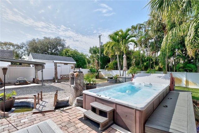 view of pool with an outdoor hot tub, a patio area, and an outbuilding