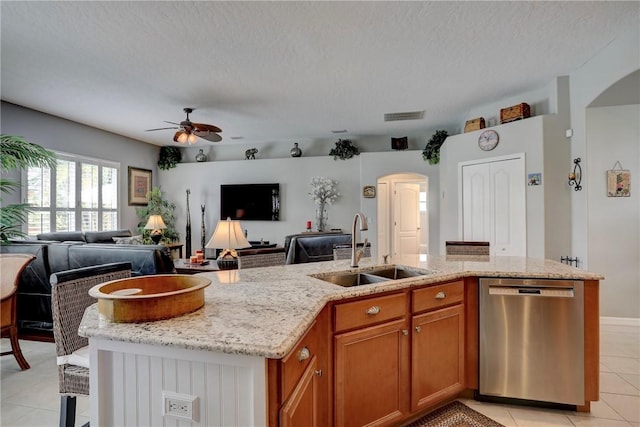 kitchen featuring a textured ceiling, dishwasher, sink, and a kitchen island with sink