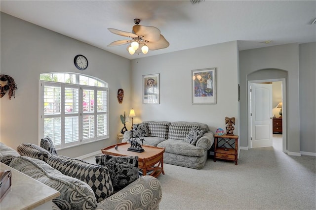 carpeted living room with ceiling fan