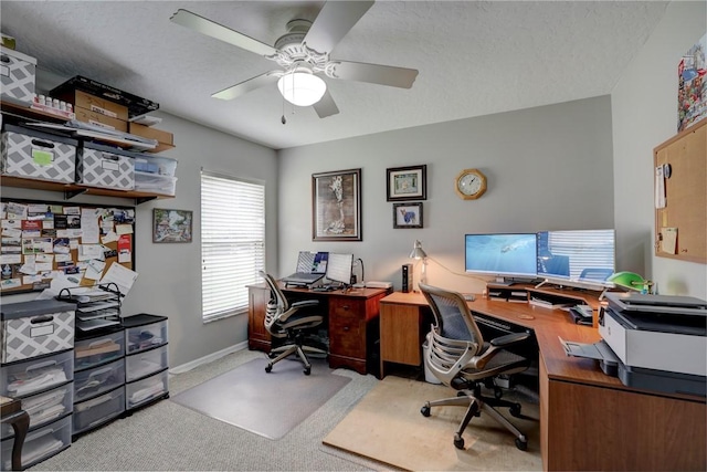 home office with a textured ceiling, ceiling fan, and light carpet