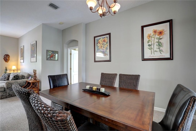 dining space featuring carpet floors and an inviting chandelier