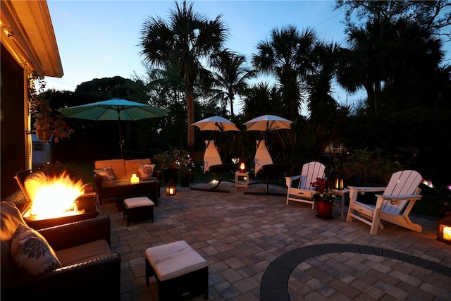 patio terrace at dusk featuring an outdoor living space with a fire pit