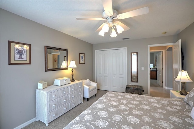 bedroom with ceiling fan, light colored carpet, and a closet