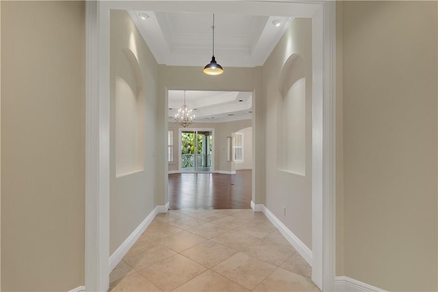 104 Island Plantation Ter Unit 304, Vero Beach, FL 32963 - corridor featuring a chandelier, crown molding, arched walkways, a raised ceiling, and baseboards