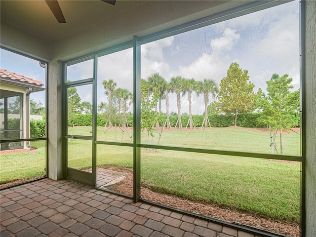 unfurnished sunroom with ceiling fan