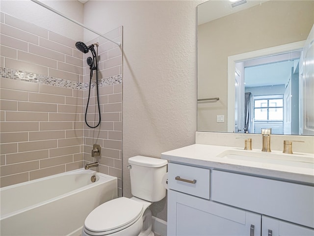 full bathroom featuring tiled shower / bath, toilet, and vanity