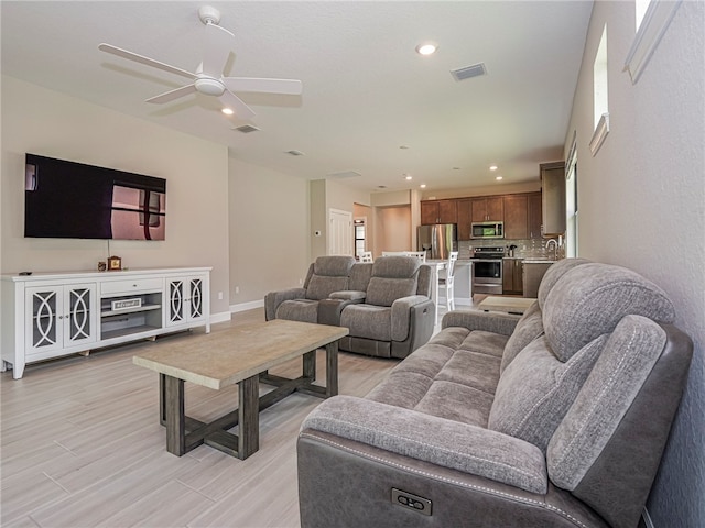 living room featuring light hardwood / wood-style floors and ceiling fan