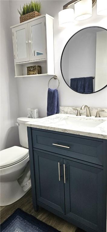 bathroom with vanity, toilet, and wood finished floors