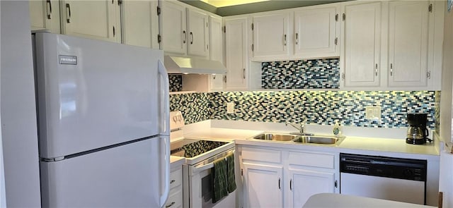 kitchen featuring under cabinet range hood, backsplash, white appliances, and a sink