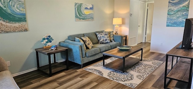 living room featuring wood finished floors, visible vents, and baseboards