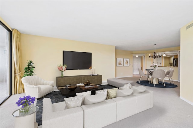 living room featuring carpet flooring and a notable chandelier