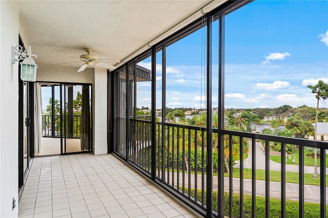 unfurnished sunroom featuring ceiling fan