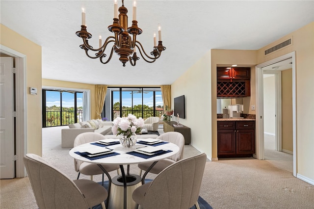 carpeted dining room featuring an inviting chandelier