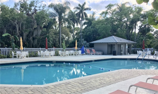 view of swimming pool featuring an outdoor structure and a patio