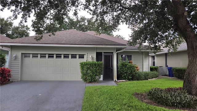 single story home with a garage and a front lawn