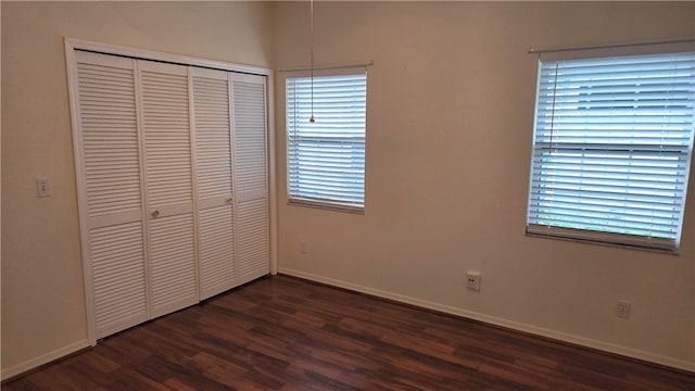 unfurnished bedroom featuring dark wood-type flooring and a closet