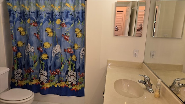 bathroom featuring curtained shower, vanity, tile patterned floors, and toilet