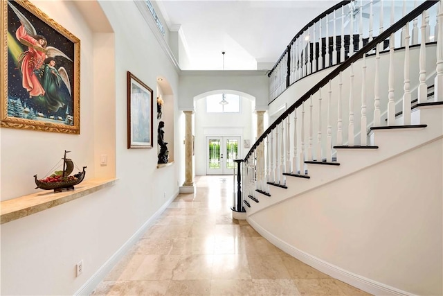 entrance foyer featuring french doors and a towering ceiling