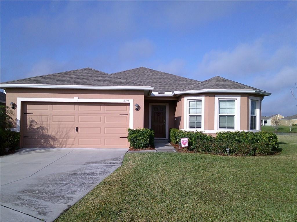 view of front of property with a garage and a front lawn